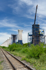 Obraz premium Workers construct bridge piers for a railway.