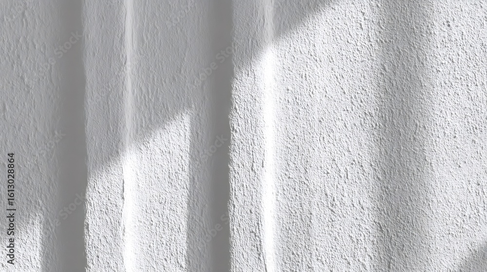 Poster sunlight is creating shadows on a white textured wall, providing a minimalist and abstract backgroun