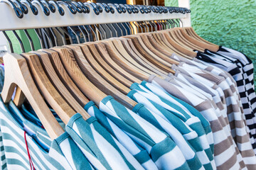 Colorful display of clothing on hangers in a retail store showcasing a variety of styles and...