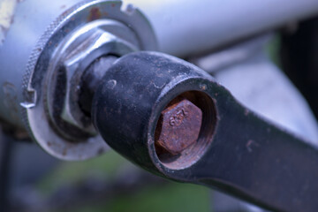 Rusty pedal axle of an old bicycle displaying wear and age in a natural outdoor environment