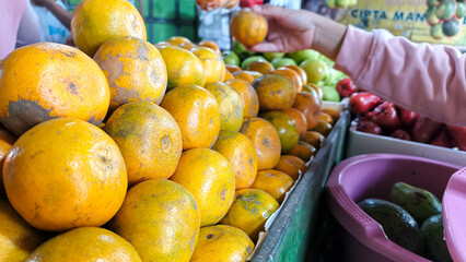 Fresh oranges piled high at a market stall.