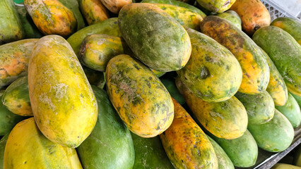 Close-up view of many ripe and unripe papayas.