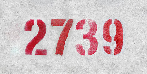 Red Number 2739 on the white wall. Spray paint.