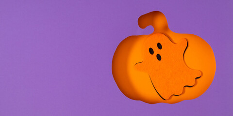 Stylish and creative Halloween background with cut out orange pumpkin silhouette and cute ghost on...