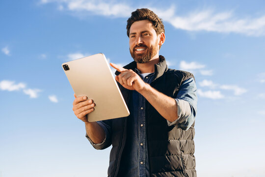 Farmer using digital tablet in field: implementing modern technology in agriculture