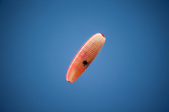 Ein Paragleiter mit Motorantrieb am Himmel.
