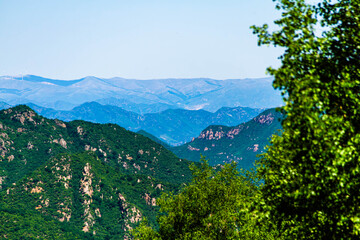 Sunset Over Mountain Ridge with Distant City Skyline