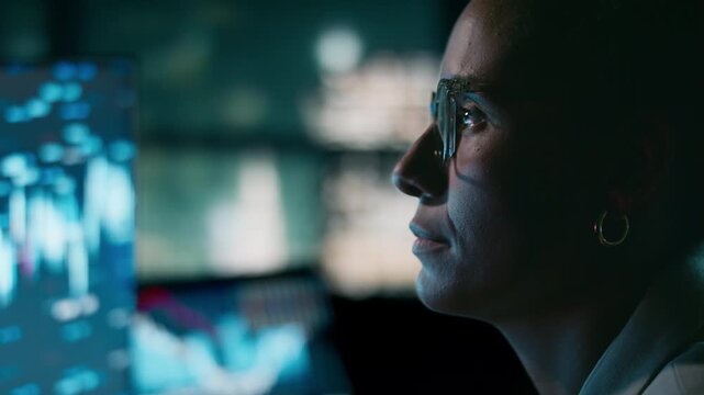 Close-up of businesswoman analysing stock market data in skyline office at night - Powered by Adobe