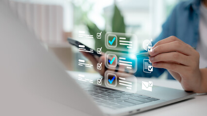 Hand using digital checklist interface on laptop and smartphone. Concept of productivity, task management, goal tracking, online planning system, and efficient workflow organization.
