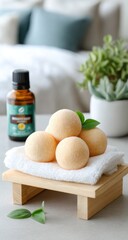 Bath bombs on a small wooden stand with a towel, essential oil bottle, and plant behind it. Focus on relaxation and skincare. Soft lighting and blurry background