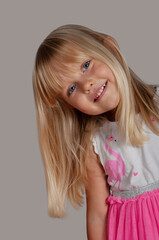 happy blond blue-eyed girl 4 years old looking curious and smiling