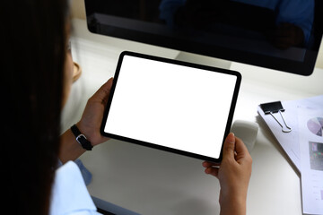 Close up of office worker holding a digital tablet with blank white screen at a desk