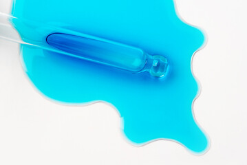 Drops of cosmetics and a pipette on a white background. A product for skin, face or hair care.