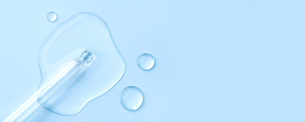 Drop of cosmetics and a pipette on a blue background. A product for skin, face or hair care.