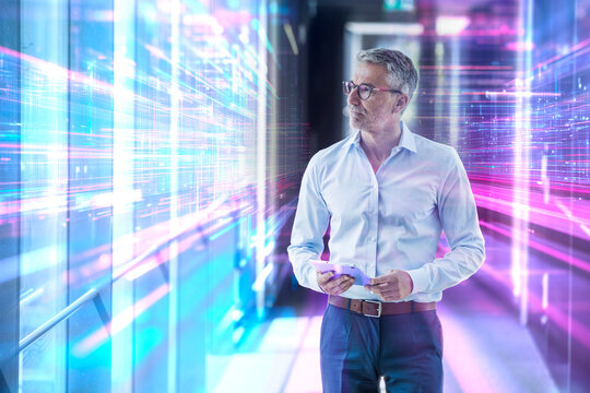 Engineer using tablet in futuristic server room with digital data - Powered by Adobe