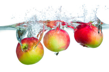 Fresh Red Apples Splashing into Clear Water with Bubbles and Ripples