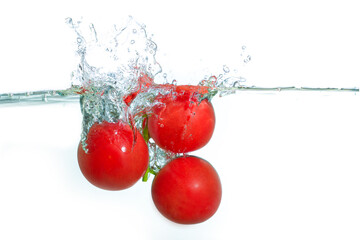 Fresh Red Cocktail Tomatoes Splashing Into Clear Water Against White Background