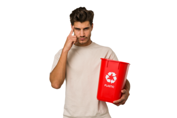 Young caucasian man holding a plastic trash isolated pointing temple with finger, thinking, focused on a task.