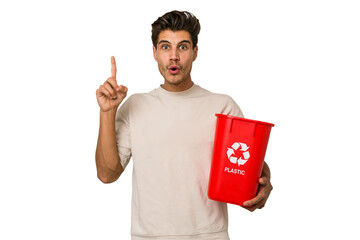 Young caucasian man holding a plastic trash isolated having some great idea, concept of creativity.