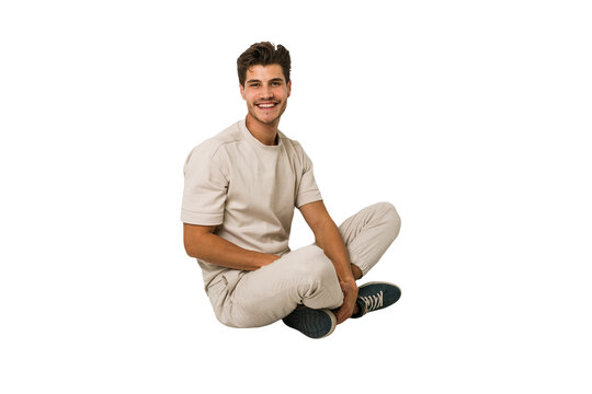 Fototapeta Young caucasian man sitting on the floor isolated on white background