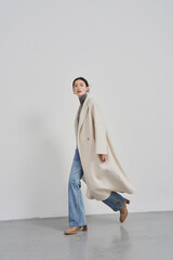 Young Asian woman in stylish outfit walking elegantly.