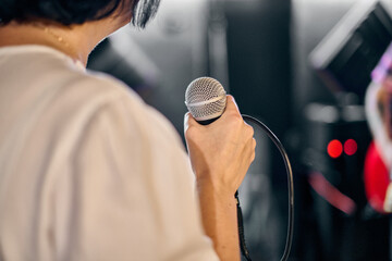 Young woman holding microphone in music rehearsal © TRAVELARIUM