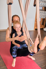 Mother and child enjoy aerial yoga in studio