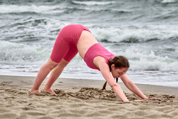 Yoga at baltic shore on cloudy day