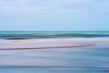 Smooth pastel tones of sea and sky melt into one continuous dream.