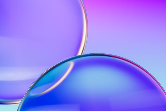 3d glass bubbles with reflections on purple and blue background