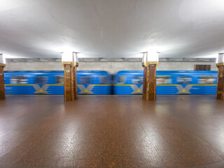 Train at the subway station in motion, side view, empty station. Heroiv Dnipra, Kyiv, Ukraine.
