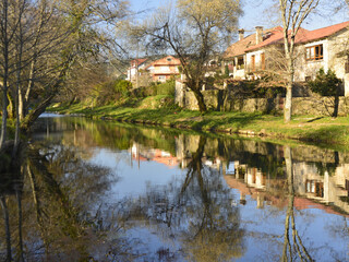 Obraz premium The Tamuxe River flowing serenely between beautiful houses in Galicia