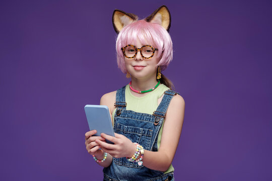 Girl in cosplay costume with animal ears using smartphone indoors