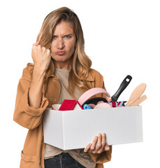 Young Caucasian blonde moving with a box showing fist to camera, aggressive facial expression.