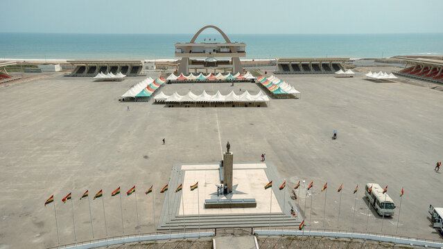 Aerial view of the expansive Black Star Square, framed by the serene ocean and fluttering Ghanaian flags, a scene of national pride, Osu Klottey, Greater Accra Region, Ghana.