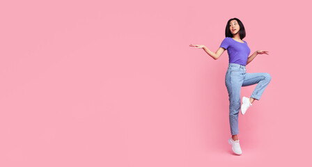 Having Fun. Full body length portrait of happy young asian woman jumping, dancing and looking aside...