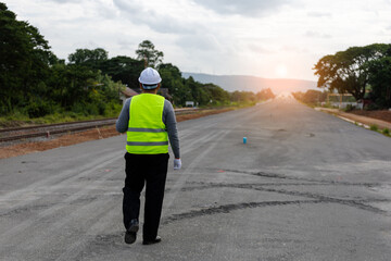 Obraz premium A engineer on a vast road construction site. Traffic cones and barriers are, signifying area in large infrastructure projects.