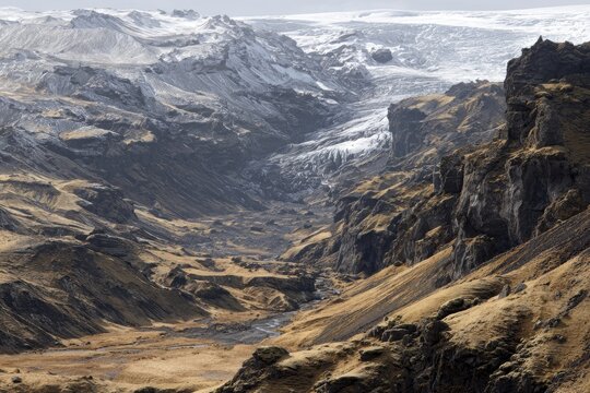 High-altitude view of a glacial valley, snow-capped mountains, and dry, brown terrain