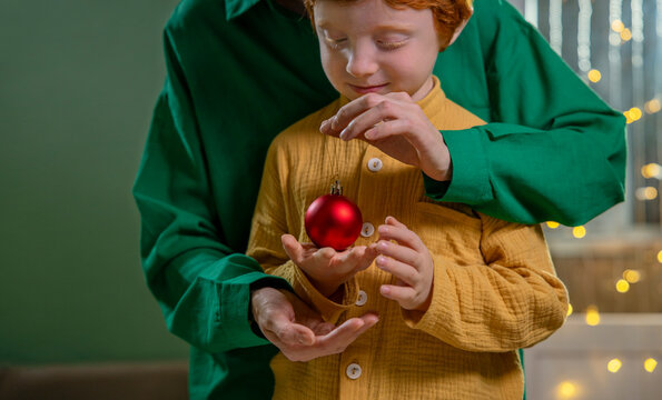 Mother and child holding Christmas ornament together indoors