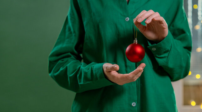 Hand holding a red Christmas bauble at home for the holiday season