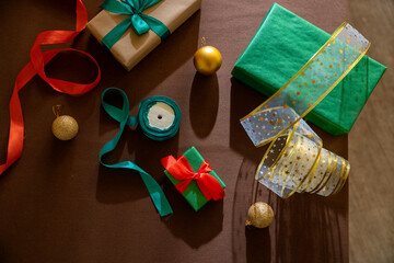 Christmas gifts and ribbons on table with festive decorations