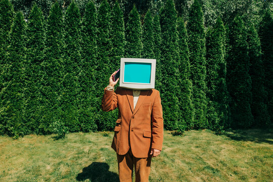 Man with retro monitor head in suit outdoors as visual metaphor for digital identity