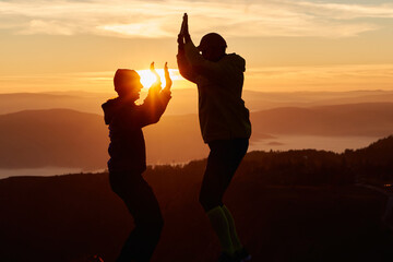 A joyful couple celebrates their victorious ascent to the mountain summit, embracing each other...