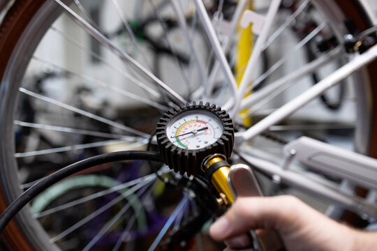 Close up view of air pressure gun inflating bicycle tire.