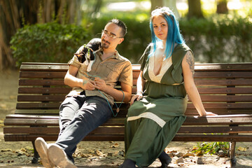Couple relaxing on park bench with cat