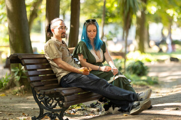 Couple relaxing on bench in park with cat