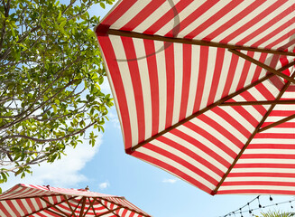 Beach umbrella red and white color with under sky view background.