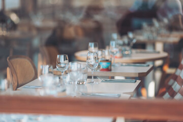 Elegant dining setup with glassware and cutlery in a modern restaurant during daylight