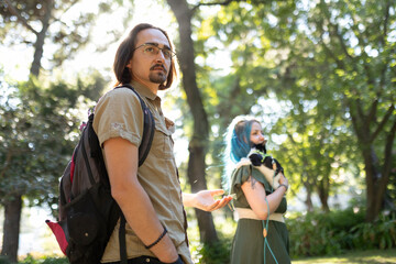 Hikers discussing while walking in nature with small dog