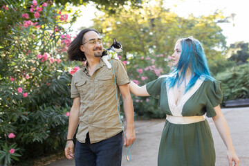 Couple walking with kitten on leash in park
